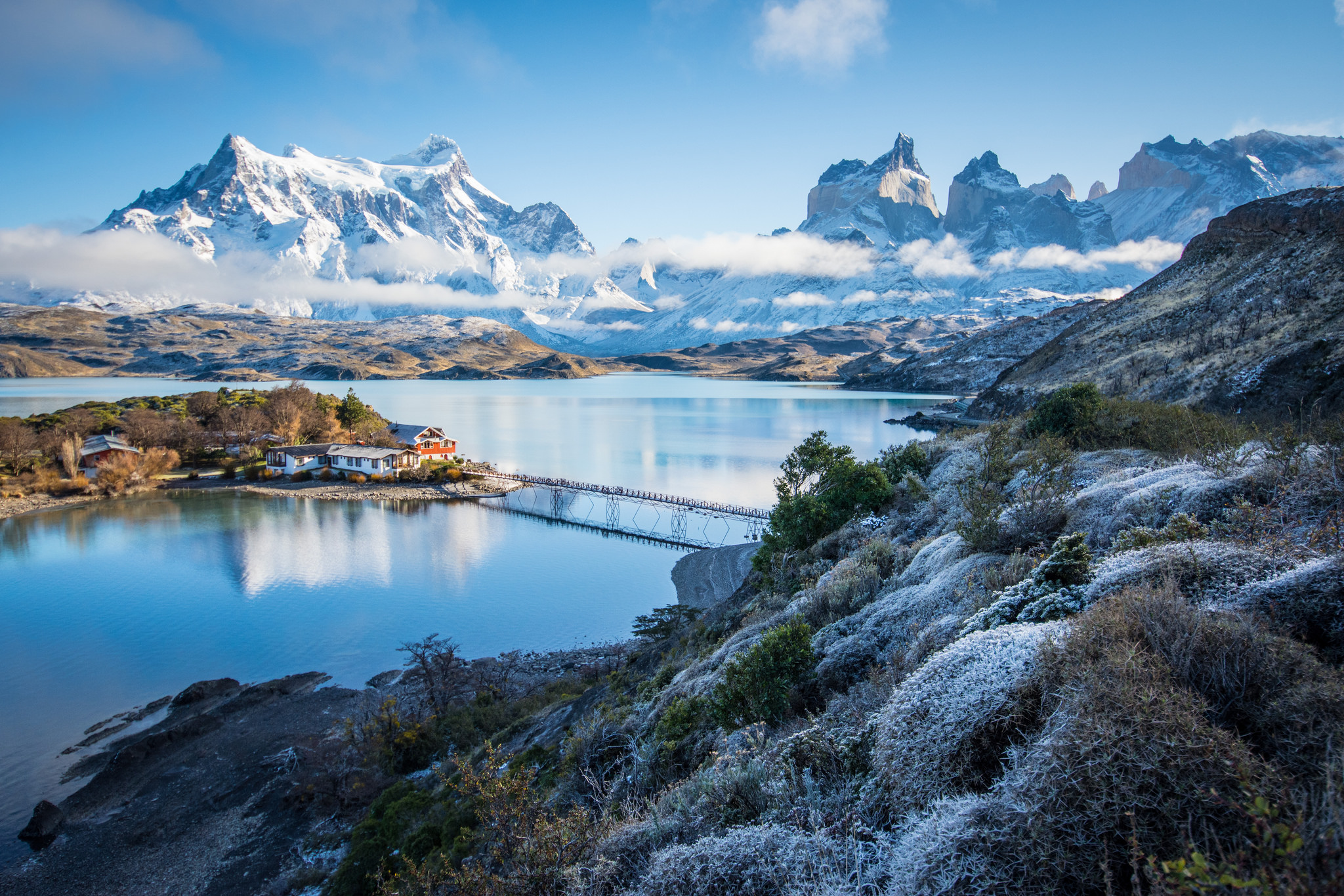 Snow-dusted mountains and lakes in Torres del Paine, with a footbridge to a small island